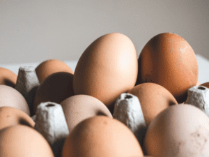 Telur cokelat dengan berbagai nuansa tersusun di atas nampan karton abu-abu.